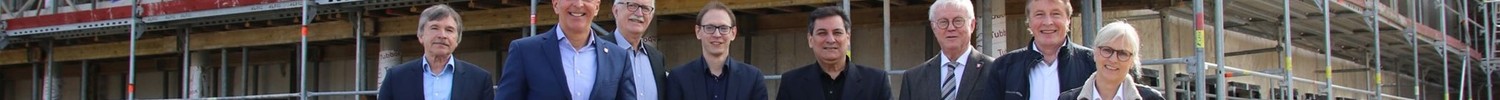 Ein Foto von einer Gruppe Menschen vor der Baustelle des Klinikneubaus