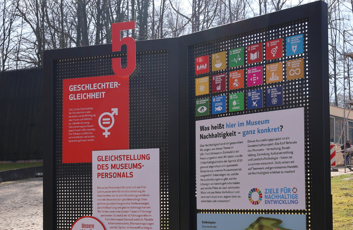 Ein Foto von einer Infotafel zu Klimaziel 5 auf einer Wiese