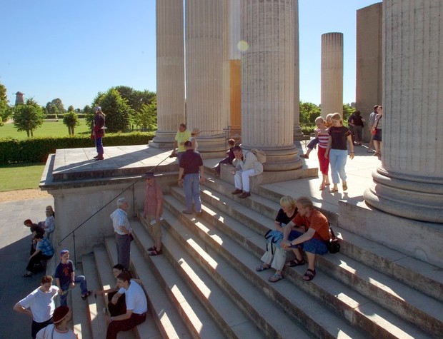 Das Bild zeigt den LVR-Archäologischen Park Xanten mit Besucher:innen, die auf Stufen sitzen oder diese hinauf- und hinabsteigen.